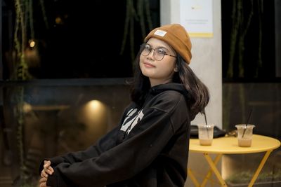 Portrait of young woman standing in cafe