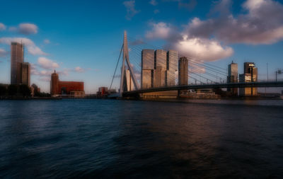 Bridge over river in city against sky