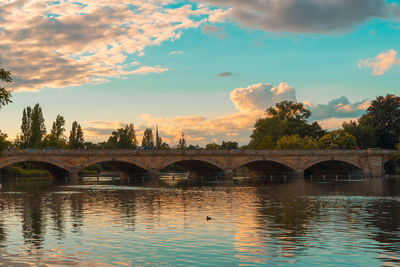 Arch bridge over river against sky