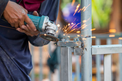 Midsection of man working on metal