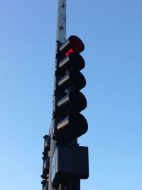 Low angle view of road signal against clear blue sky