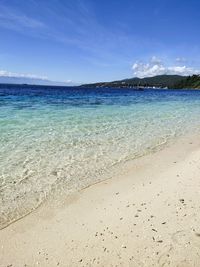 Scenic view of beach against blue sky