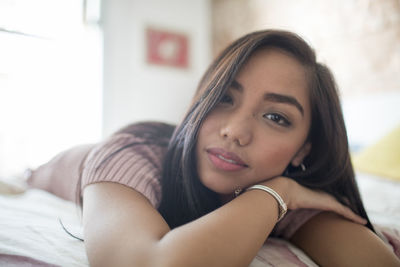 Young woman lying on her bed