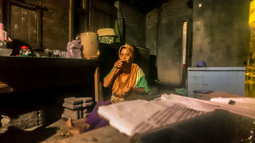 Woman sitting on table in building