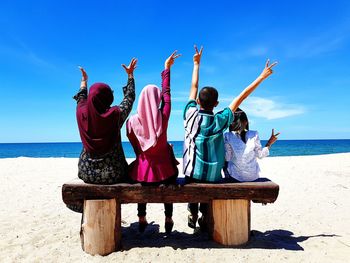 People at beach against blue sky