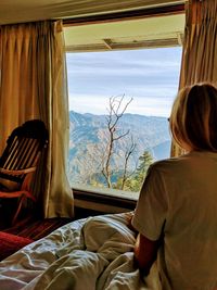 Rear view of woman looking at window