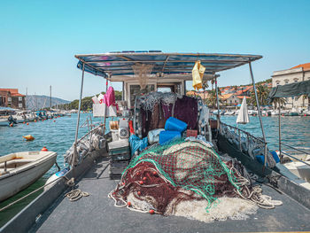 Fishing boats moored in sea against clear sky