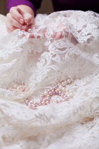 Cropped hands of woman stitching wedding dress