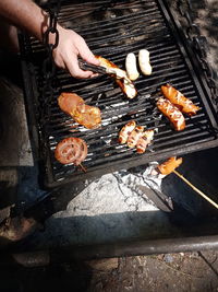 High angle view of man preparing food on barbecue grill