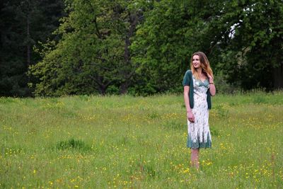 Young woman standing on grassy field