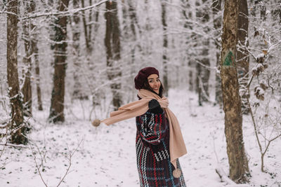 Rear view of woman standing in forest during winter