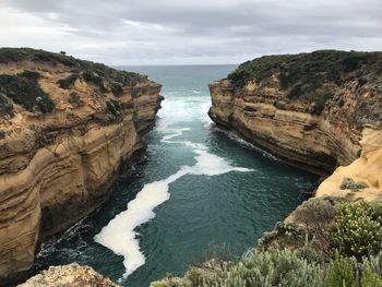 Scenic view of rocks in sea against sky