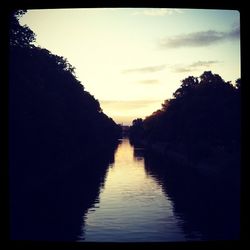 Scenic view of river against sky at sunset