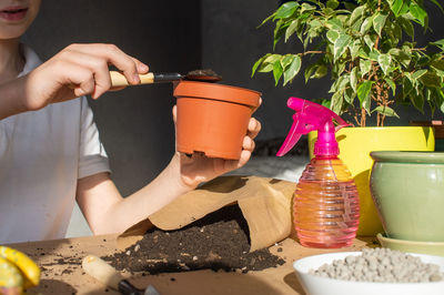 A cute boy is holding a seedling tool in his hands. care of home plants, fertilize the soil