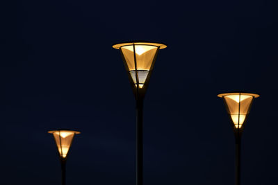 Low angle view of illuminated street light against sky