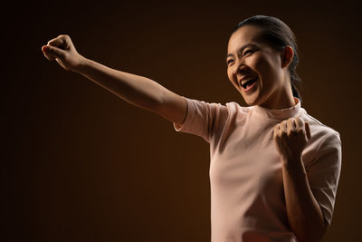 Smiling young woman against black background