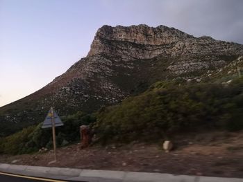 Rock formations by road against clear sky