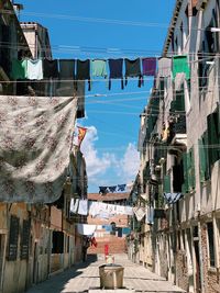 Typical street in venice italy with building facades and hanging clothes sunlight blue sky 