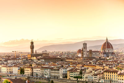 High angle view of buildings in city at sunset