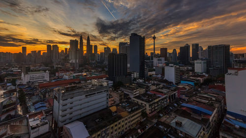 Aerial view of modern buildings in city against sky during sunset