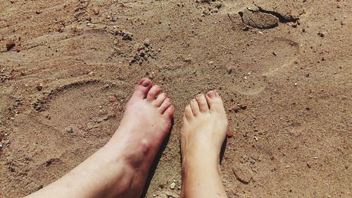 Low section of woman feet on sand at beach