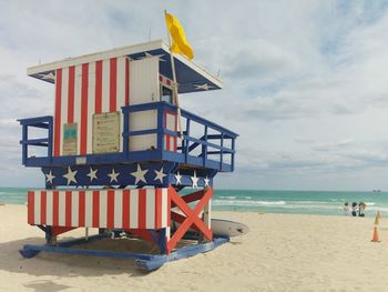 Lifeguard hut on beach against sky