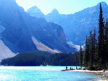 People in lake against mountain range