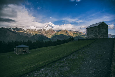 Scenic view of houses and mountains against sky