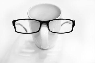 Close-up of eyeglasses on table against white background