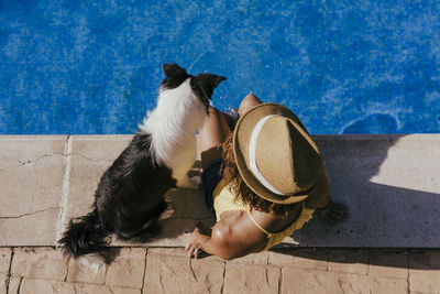 High angle view of woman with dog on poolside