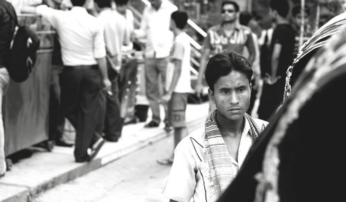 Portrait of young man standing on street in city