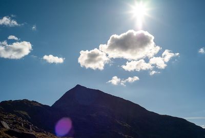 Low angle view of mountains against sky on sunny day