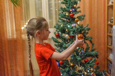 Full length of girl in christmas tree
