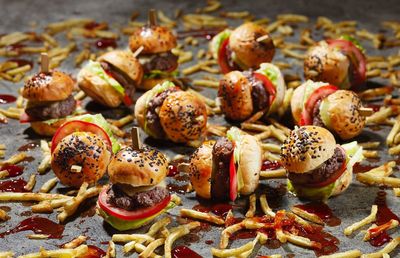 Close-up of burgers and french fries messed with ketchup on table