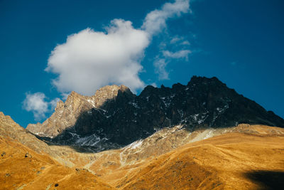 Scenic view of snowcapped mountains against blue sky