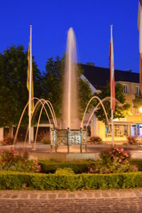 Fountain against trees at night