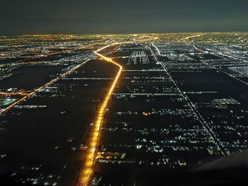 High angle view of illuminated cityscape against sky at night