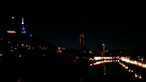 Illuminated cityscape against clear sky at night