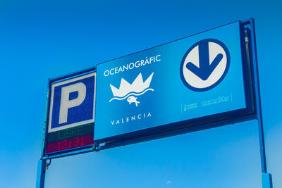 Low angle view of information sign against clear blue sky