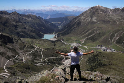 Rear view of woman standing on mountain against sky