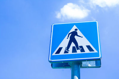 Low angle view of road sign against blue sky