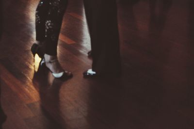 Low section of man standing on hardwood floor