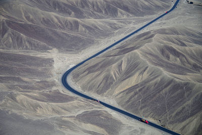 Aerial view of car moving on road amidst mountains