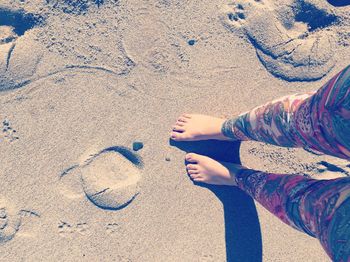 Low section of woman standing at beach