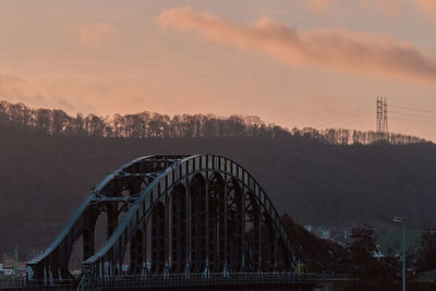 Old iron bridge over river meuse, belgium at dawn