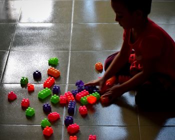 High angle view of girl playing with toys while sitting on floor at home