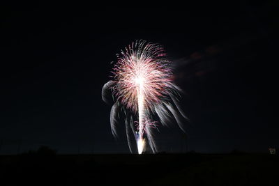 Low angle view of firework display at night