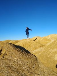 Low angle view of man standing on land against clear sky