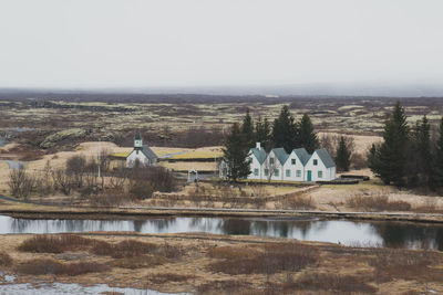 River by houses against sky