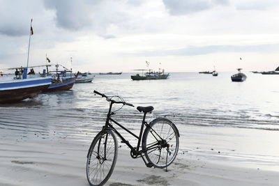 Bicycles on beach against sky